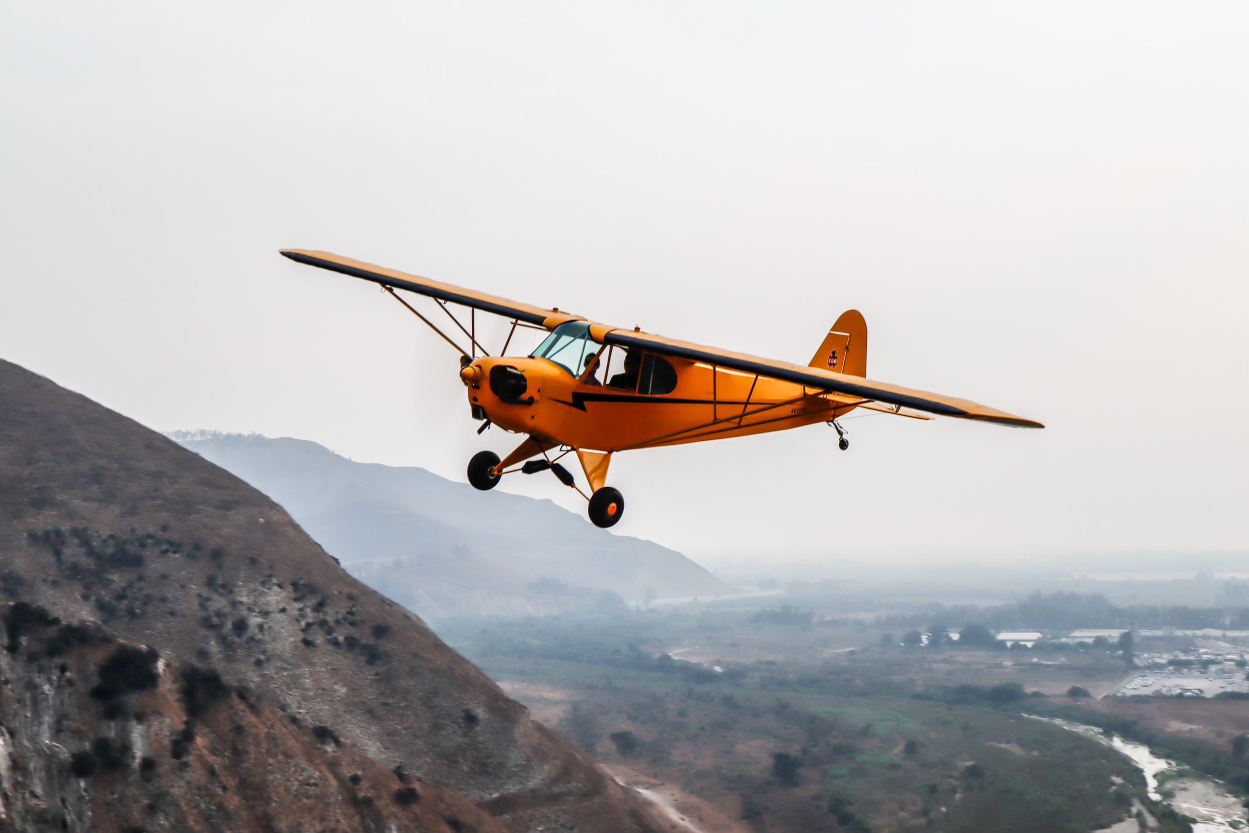 small airplane flying over mountains